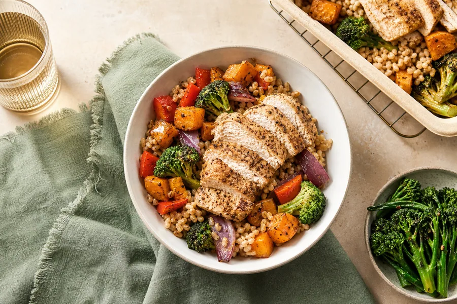Reheated chicken grain bowl with broccoli, peppers and squash